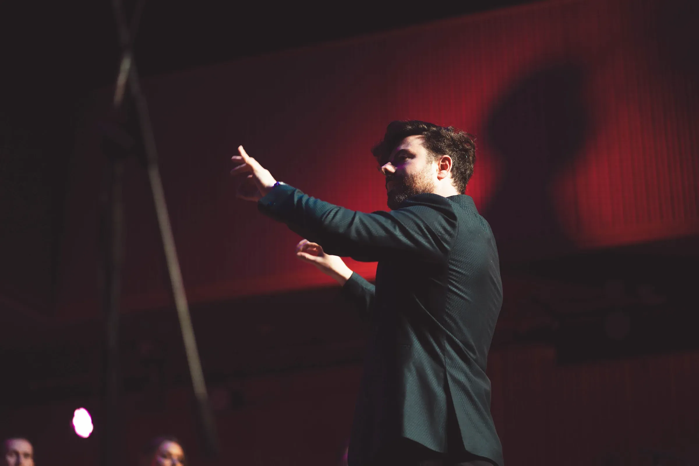 Conducting the choir under red stage light